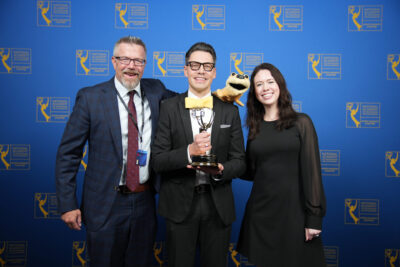two men and one female holding award