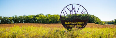 Gleandalough State Park Sign in a field of grass.