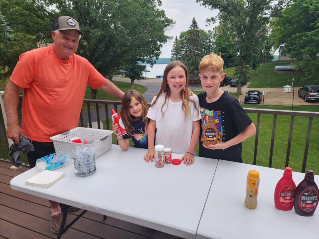 Brian Leonard takes a break from yard work to assist grandkids with the weekly ice cream social.