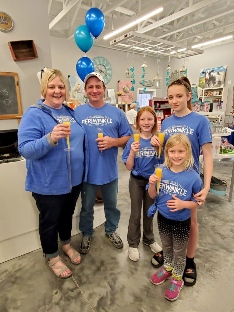 A group of people celebrate the store re-opening