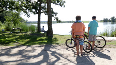 People with bicycles near lake Adley