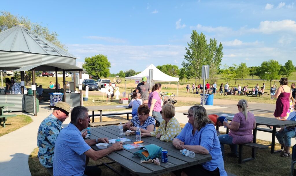 People sitting outdoors at Spring into Summer on picnic tables